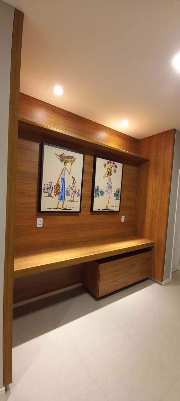 Home office com painel e bancada em madeira